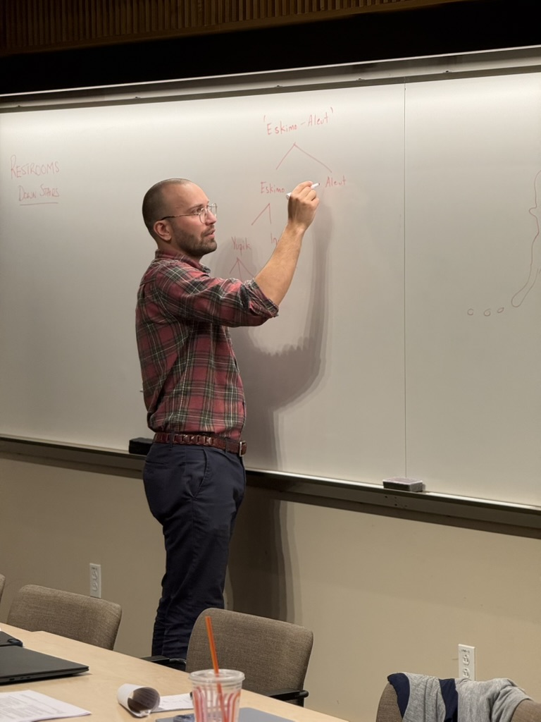 Dr. Kaden Holladay drawing an Eskimo-Aleut language tree on the whiteboard at Harvard